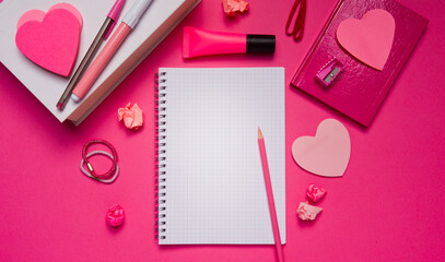 Girly pink desktop and stationery with blank notebook and pencil.
