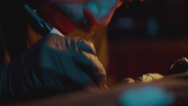 Professional Male Tattoo Artist Makes A Tattoo In The Studio - close up