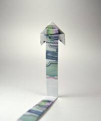 Arrow origami made of rubles bills on a white background
