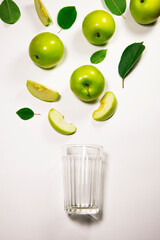 Fresh apple juice flowing from apple piece into the glass