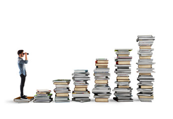 Boy with binoculars on a scale of books