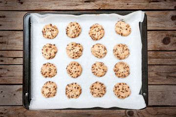 Homemade chocolate chip cookie just baked on a tray over wooden background