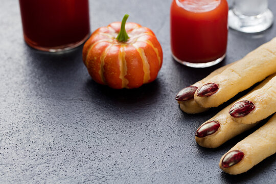 Cookies Witch's fingers with bloody cocktail for Halloween party celebration. Black stone background Copy space.