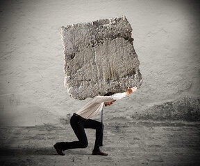 Businessman walking with a heavy boulder on his back - obrazy, fototapety, plakaty