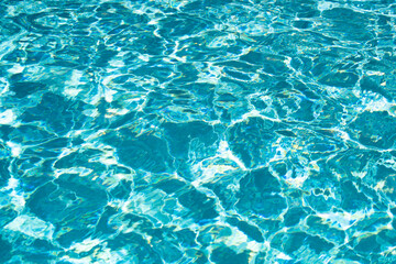 Fototapeta premium Ripple Water in swimming pool with sun reflection. Wavy water background.