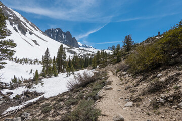 Hiking trail through snowy mountains in spring