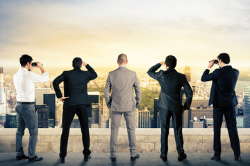 Businessmen looks at the city from the roof with binoculars