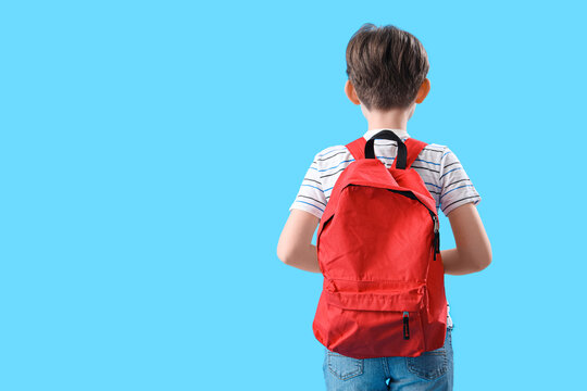 Naklejka Little boy with schoolbag on blue background, back view