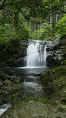 Naklejka na ściany i meble Waterfall deep in the mountains