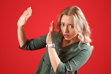Young woman having panic attack on red background