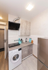 Kitchen studio with induction electric hob and shelves and cupboards for dishes