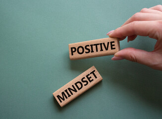Positive Mindset symbol. Concept words Positive Mindset on wooden blocks. Businessman hand. Beautiful grey green background. Business and Positive Mindset concept. Copy space.