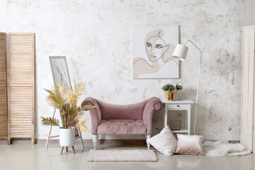 Interior of living room with cozy pink armchair, mirror and painting