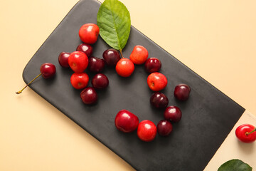 Board with sweet cherries on light background