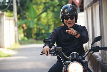 Fototapeta na wymiar Asian man motorbike in black leather jacket travel rider trip. Handsome Men wear sunglass outdoor lifestyle freedom rider. Men trendy hipster cool person. Young asian man hobby ride with motor bike