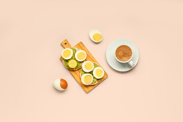 Wooden board of rice crackers with boiled eggs and avocado on pink background