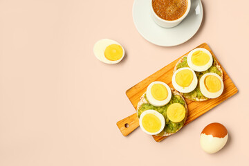Wooden board of rice crackers with boiled eggs and avocado on pink background