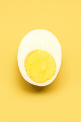 Half of tasty boiled egg on yellow background