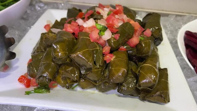 Delicious dolma stuffed grape leaves rice, white yogurt sauce. Lebanese dolma sarma on plate. Lebanon turkish greek middle eastern cuisine. name Yaprak sarma . Stuffed grape leaves.