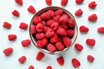 Bowl with fresh raspberry on light background, closeup