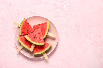 Plate with sweet watermelon sticks on pink background