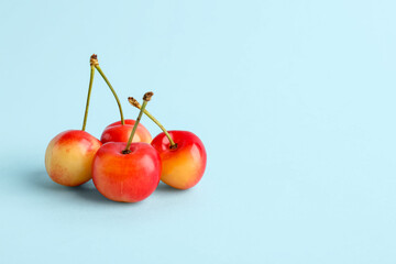 Sweet yellow cherries on blue background