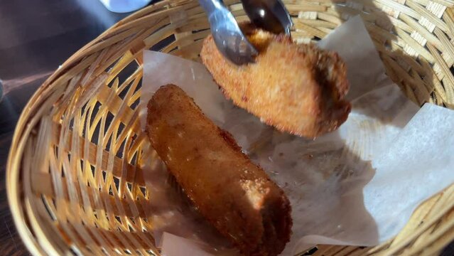 Chef pours fried banana pieces with hot cane sugar oil on a hot frying pan in slow motion. High quality 4k footage