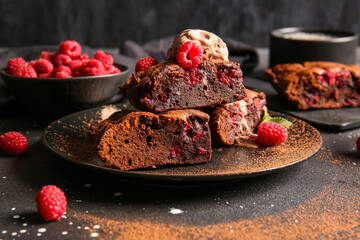 Plate with pieces of raspberry chocolate brownie and ice-cream on black background