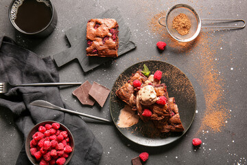 Plate and board with raspberry chocolate brownie on black background