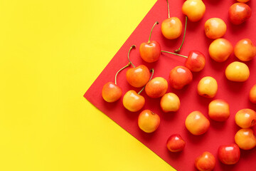 Many sweet yellow cherries on colorful background