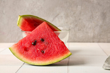 Fototapeta na wymiar Piece of fresh watermelon on white tile table