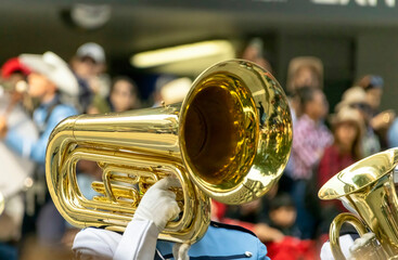 A marching band instrument at a public parade in summer. A person playing tuba, part of a marching...
