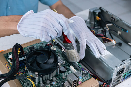A technician is repairing a computer by cleaning the cooling fan. Computer CPU