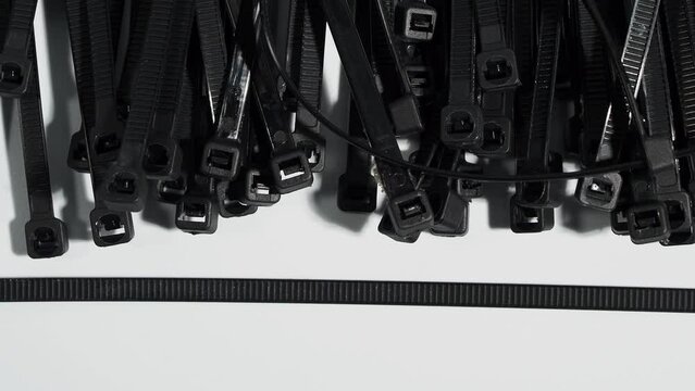 Plastic black ties on a white background. Plastic ties for cables.