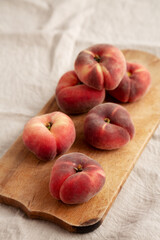 Organic Donut Saturn Peaches on a rustic wooden board, side view.