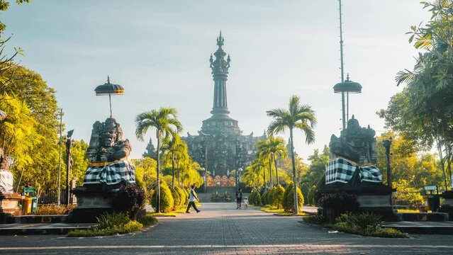 Bajra Sandhi monument in the rays of the rising sun with silhouette jogging people in the morning. Denpasar, Bali Indonesia 4K