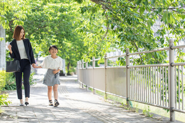 Fototapeta na wymiar 歩道を歩く親子　Parent and child walking on the sidewalk 
