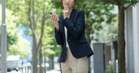 携帯を持ち悩む日本人女性