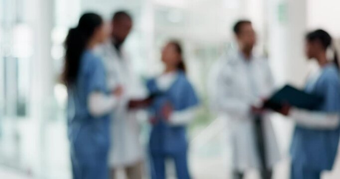 Doctors, nurses and staff talking in a hospital for planning schedule and collaboration with a team. Blurred people or medical workers together for a discussion, conversation or health care at work
