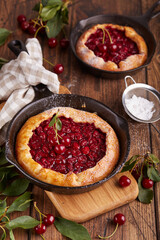 Pie tart with cherries and sugar powder. Delicious homemade open sweet galette with seasonal berries.