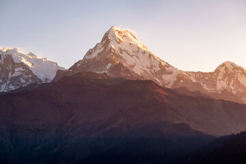 Machhapuchhre Peak, the sunrise area of annapurna base camp, Nepal, is a very beautiful peak of the Himalayas. snow capped peaks photo from a distance The red-orange morning sun shines brightly.