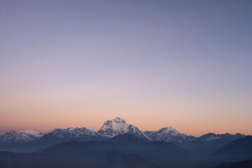 Fototapeta na wymiar Machhapuchhre Peak, the sunrise area of annapurna base camp, Nepal, is a very beautiful peak of the Himalayas. snow capped peaks photo from a distance The red-orange morning sun shines brightly.