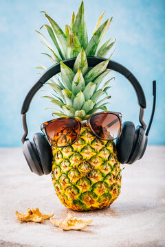 Summer concept - Pineapple hipster in sunglasses and headphones with melon alen lemons, creative art fashionable vacation concept