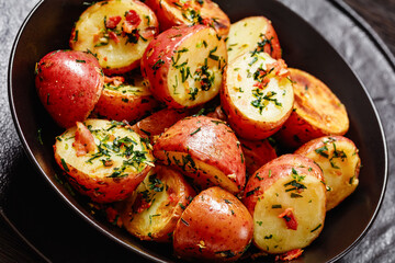 Herbs Garlic Potatoes in black bowl, top view