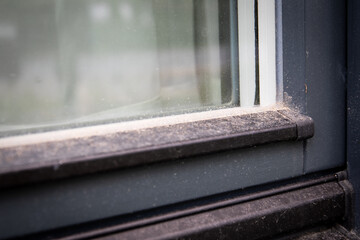 Window and window frame from the outside with sand and dust