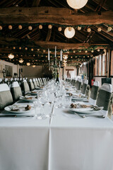 Table set for a wedding reception with white table cloth and table cutlery 