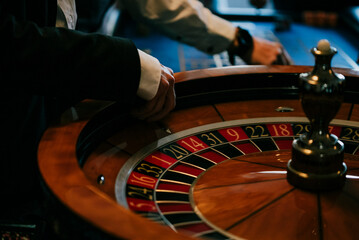Roulette dealer releasing the ball in roulette wheel casino
