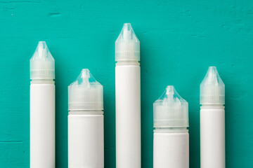 Electronic cigarettes liquid bottles on blue background