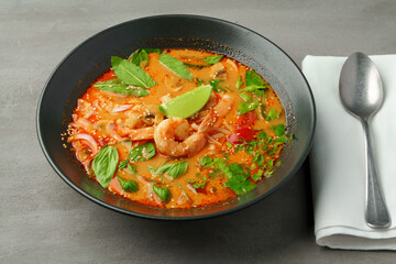Tom Yum spicy Thai soup on gray background