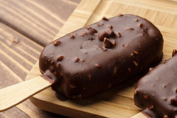 Chocolate cake pops ice creams on wooden board close up